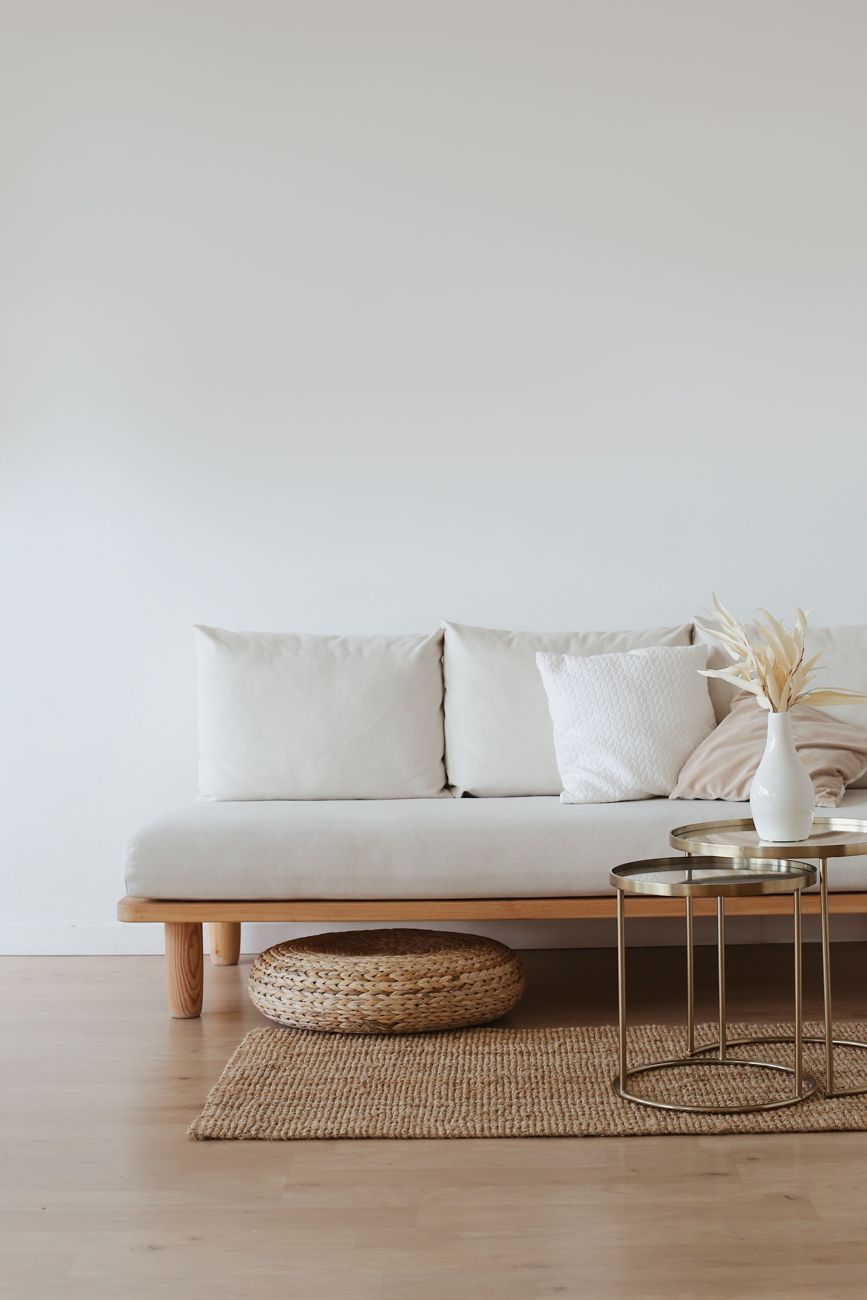 Helles Sofa mit Holzgestell, Juteteppich und Beistelltischen